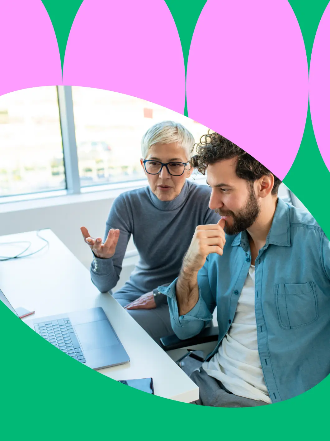 Experienced mentor explaining sales strategy to a colleague at a laptop